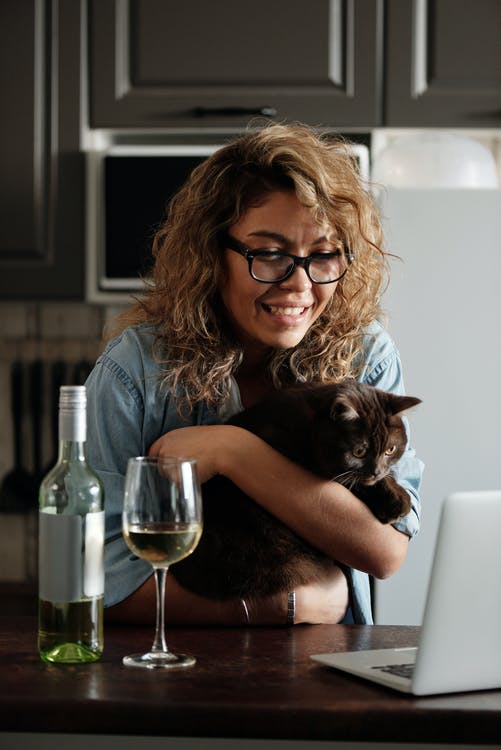 Woman holding Cat with glass of wine